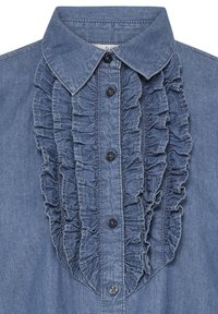 Chemise en denim avec col classique, boutons noirs sur le devant, et détails superposés de volants verticaux de chaque côté des boutons.
