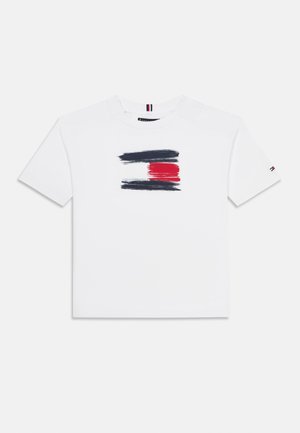 T-shirt en coton blanc avec un design de coups de pinceau en bleu marine, rouge et blanc au centre. Manches courtes et encolure ras du cou classique.