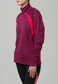 Bordeaux långärmad zip-up tröja med rosa detaljer och hög krage. Har en mjuk textur och figursydd design. Logotyp på bröstet.