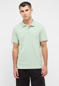Šviesiai žalia medvilninė polo mar�škinėliai su trimis sagomis, trumpomis rankovėmis ir maža logotipu ant krūtinės.
