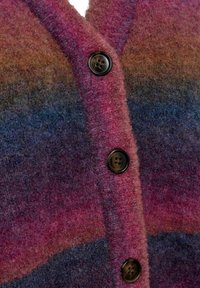 Cardigan v gradientních barvách růžové a modré, vyrobený z texturované látky. Obsahuje černé knoflíky a má výstřih do V.