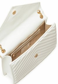 Witte gewatteerde handtas met een gouden ketting en hardware, met een open flap en beige interieur met een klein compartiment en logo.