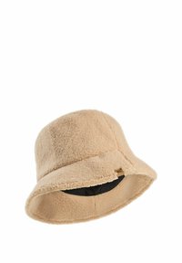 Beige fleece emmerhoed met een zachte textuur, brede flodderrand en een zwarte voering. Heeft een kleine gouden labelaccent aan de zijkant.