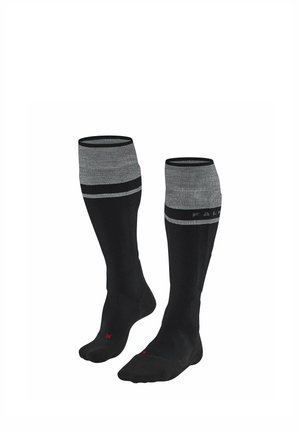 Paire de chaussettes noires montant jusqu'aux genoux avec des bordures grises et deux bandes horizontales grises près du haut sur fond blanc.