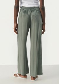 Lightweight, elastic-waist, wide-leg pants in muted green fabric, featuring no visible patterns and a smooth texture.