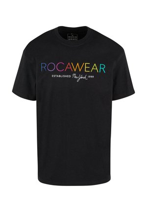 T-shirt en coton noir avec le texte "ROCAWEAR" en dégradé de couleurs, et "ESTABLISHED New York 1999" en blanc, design classique à col rond.