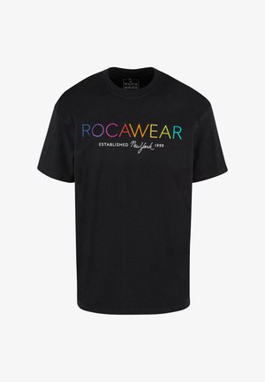 Mustan puuvillapaidan, jossa on gradienttiväreillä oleva "ROCAWEAR" -teksti ja valkoinen "ESTABLISHED New York 1999", klassinen pyöreä pääntie.