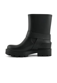 Czarne gumowe botki za kostkę o wysokości do połowy łydki, z oplatającym paskiem i masywną, teksturowaną podeszwą. Gładkie, matowe wykończenie.