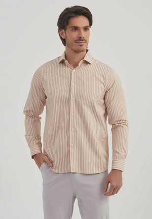 Chemise à manches longues brun clair avec des rayures blanches verticales, design à boutons, petite poche poitrine, texture lisse, et col standard.