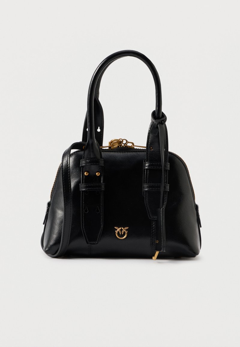 Bolsa de mão em pele preta com duas alças, alça de ombro ajustável, fecho de ouro e pequeno emblema dourado na frente.