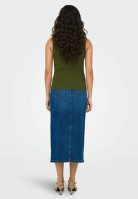 Top a righe verde oliva abbinato a una gonna di jeans lungo fino al ginocchio. La gonna ha una lineare dritta e tasche posteriori. Tacchi beige completano il look.