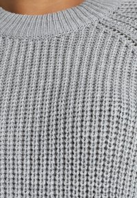 Maglione grigio a maglia con una trama a coste, colletto tondo e motivo di cuciture orizzontali.