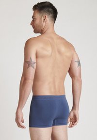 Men's navy boxer briefs made of soft fabric, featuring an elastic waistband with the brand name "Jockey," and a snug fit.