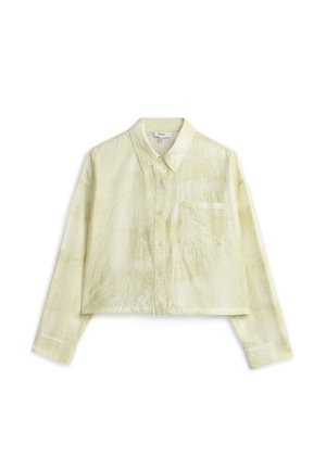 Camisa corta abotonada en amarillo claro, hecha de tela texturizada. Cuenta con un cuello clásico y un bolsillo en el pecho.