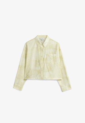 Camisa corta abotonada en amarillo claro, hecha de tela texturizada. Cuenta con un cuello clásico y un bolsillo en el pecho.