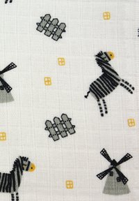 Stoff mit schwarz-grau gestreiften Zebras, Windmühlen und Zäunen auf einem weißen strukturierten Hintergrund, mit gelben Akzenten.