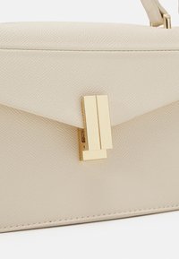 Beżowa torebka skórzana z teksturą, z zamknięciem na magnes i złotym prostokątnym zapięciem. Gładka powierzchnia, elegancki design, minimalne akcenty metalowe.