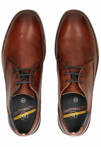 Scarpe in pelle marrone con texture perforata, dotate di lacci scuri, punta rotonda e interno imbottito con logo sulla soletta.