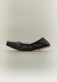 Μαύρο μπαλαρίνα παπούτσι από δέρμα με τετράγωνη μύτη και ξύλινη σόλα, εμφανίζεται σε πλάγια όψη σε ουδέτερο φόντο.