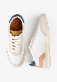 Zapatillas blancas con acentos de ante en gris claro, rosa y azul, que cuentan con una suela de goma texturizada y diseño de cordones.