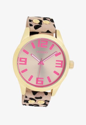 Montre dorée avec un cadran rose et de grands chiffres. Bracelet en suède imprimé léopard avec des clous dorés. Design minimaliste et lignes épurées.