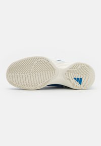 Suola di sneaker Adidas, gomma bianca con motivo testurizzato; accenti blu vicino al tallone; design flessibile per supporto e trazione.