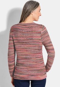 Maglione lavorato a maglia con un motivo testurizzato in varie tonalità di rosa, beige e grigio, con maniche lunghe e scollo rotondo.
