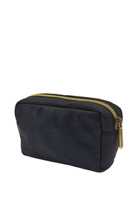 Pochette de maquillage en cuir noir avec une forme rectangulaire, une texture lisse et un accent en doré sur la fermeture éclair. Design compact pour un transport facile.