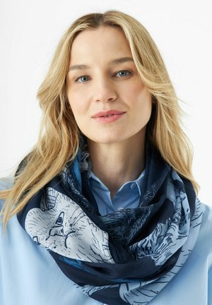 Écharpe bleue marine et claire à motifs avec des illustrations d'animaux, en tissu doux, enroulée lâchement autour du cou, présentant des textures riches.