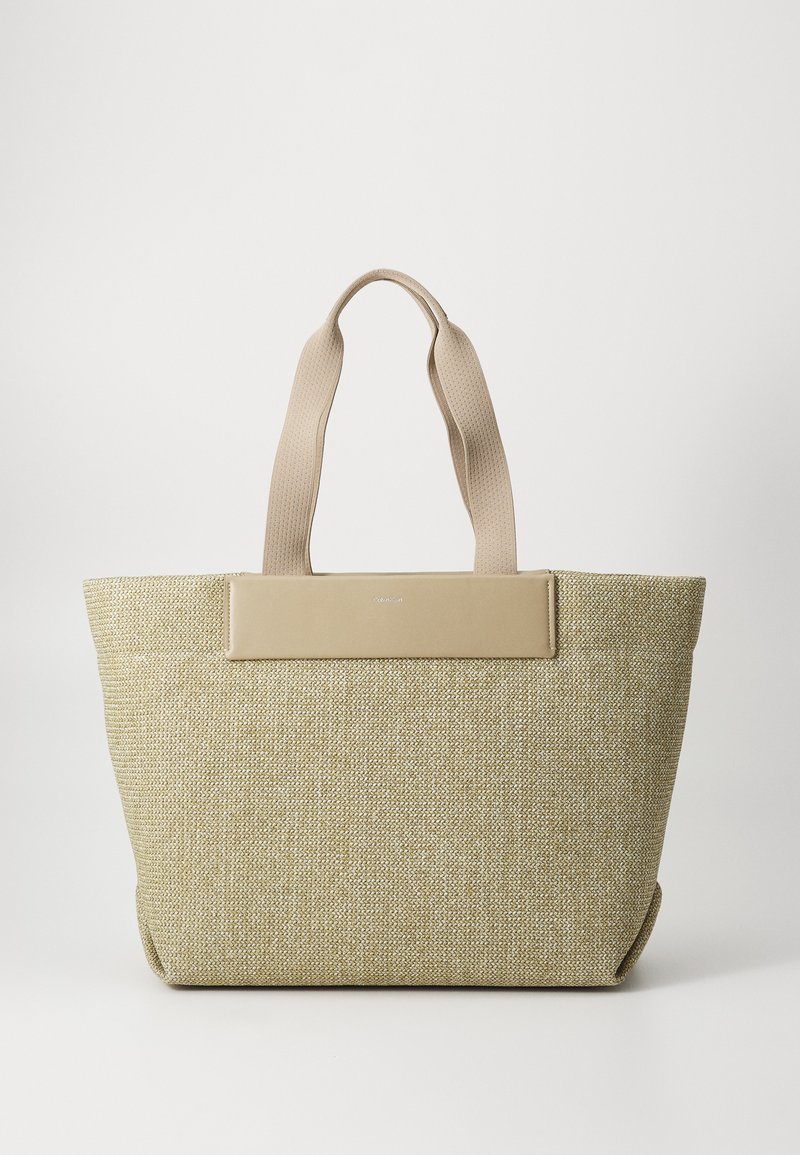 Beige geweven shopper met twee stevige handvatten, met een gladde, effen tan accent aan de voorkant; ruim met een gestructureerde vorm.