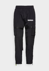 Zwarte cargo-broek met elastische taille en een glanzend logo, voorzien van zijzakken. Heeft ritsen bij de enkels en een textuurstof voor duurzaamheid.