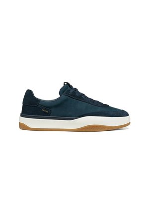 Baskets basses bleu foncé avec semelle intermédiaire blanche, semelle extérieure en gomme, fermeture à lacets et petit logo latéral au niveau du talon.