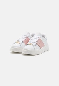 Weiße Sneakers mit einem pinken Akzentpanel, mit einer strukturierten Sohle, Schnürdesign und einem goldenen Hardware-Detail an der Zehenkappe.