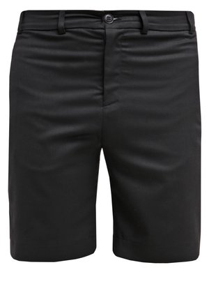 Musta crew-neck collegepaita ja mustat shortsit, jotka on valmistettu sileästä kankaasta. Shortsien sivussa on vetoketjuakkentti, ja ne on yhdistetty mustiin tennareihin.