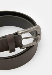 Brun læderbælte med en metallisk sølvspænde. Bæltet er glat med diskret syninger og et klassisk design.