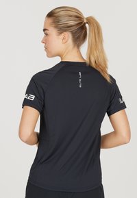 Zwart sportshirt met korte mouwen, een ronde halslijn en "ELITE LAB" branding op de achterkant en het linkermouw. Glad materiaal.