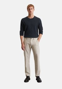 Men's outfit featuring a dark blue long-sleeve shirt and beige trousers, with a straight fit, smooth texture, and black shoes.