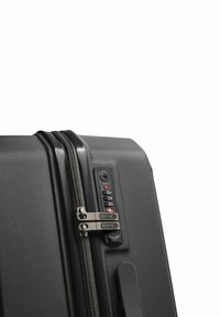 Valigia rigida nera con superficie testurizzata, doppie cerniere e un pannello con lucchetto a combinazione che presenta quadranti numerici e un indicatore di sicurezza.
