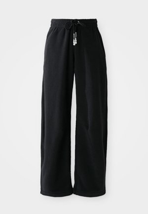 Zwarte joggerpants van zachte stof, met een trekkoord in de taille en een losse pasvorm. Geen patronen. Eenvoudig ontwerp met boordjes aan de onderkant en zijzakken.