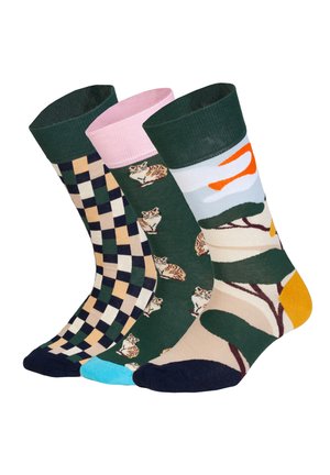 Tre farverige sokker med forskellige mønstre: ternet i beige og marineblå, grøn med katte og en naturscene med træer og orange accenter.