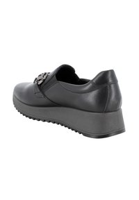 Scarpa in pelle nera con punta arrotondata e suola bassa a cuneo. Presenta un dettaglio decorativo in metallo a forma di fibbia sul lato e suola testurizzata.