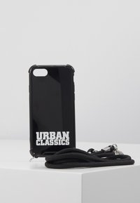 Fekete telefon tok fényes felülettel és kiemelkedő szélekkel, fehér, vastag betűs "URBAN CLASSICS" felirattal. Fekete zsinórral kiegészítve.