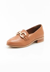 Bruine leren mocassin met een lage blokhak, voorzien van een decoratieve gouden kettingaccent en gestikte details op de bovenkant.