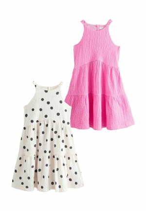 Dos vestidos de algodón sin mangas y con volantes para niñas: uno sólido en rosa, y el otro blanco con lunares negros, ambos con tela texturizada.