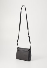 Borsa a tracolla sintetica nera con forma rettangolare sottile, superficie liscia e tracolla regolabile. Caratterizzata da una chiusura a patta e cuciture sottili.