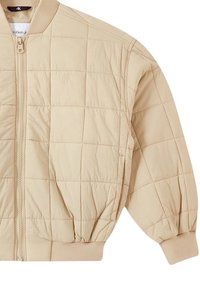 Giacca trapuntata beige con zip frontale, polsini e orlo a costine, e logo CK sul petto. Tessuto morbido, design a vestibilità rilassata.