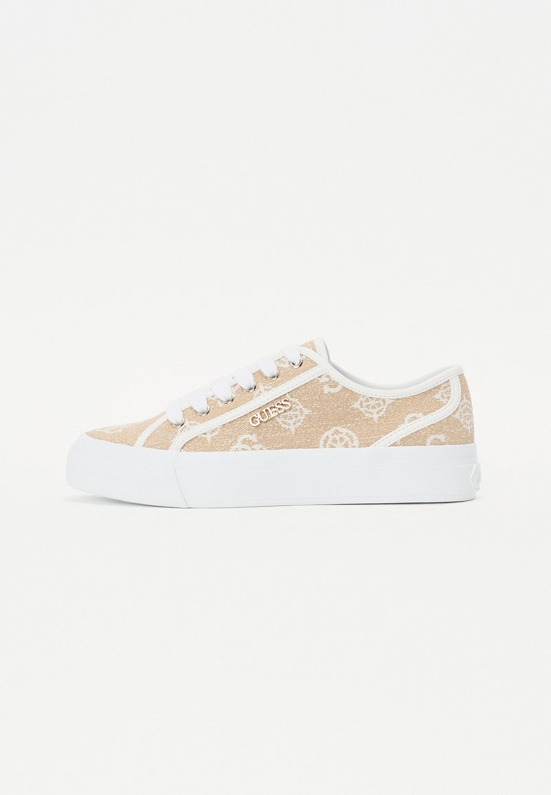 Zapatillas de lona color beige con un patrón de logo blanco, suela de goma blanca y cordones blancos; forma simple y redondeada con perfil bajo.