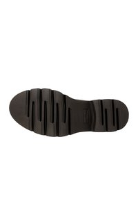 Suola di scarpa in gomma nera con un design segmentato, caratterizzata da scanalature e creste per una maggiore trazione. Forma piatta con punta e tallone arrotondati.