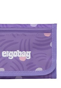 Purple fabric wallet with zipper and white "ergobag" logo, featuring subtle abstract and polka dot patterns in light colors.