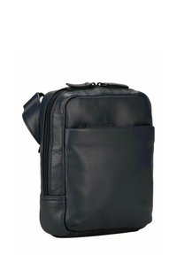 Sac bandoulière en cuir marine avec fermeture éclair, une sangle réglable, une poche avant et une texture lisse. Forme rectangulaire compacte.